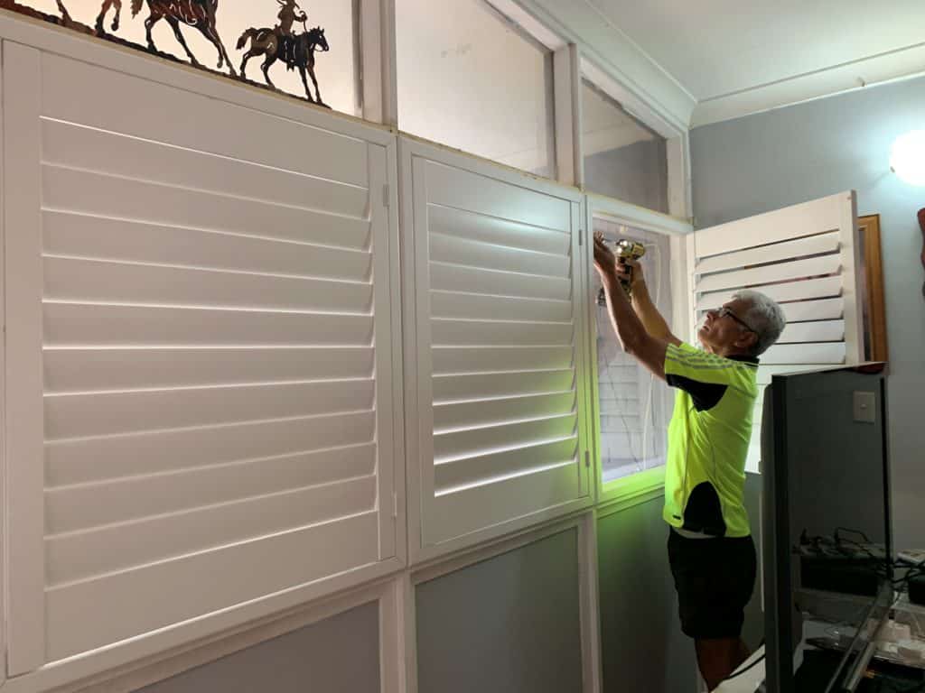 Shaedz team member installing shutter blinds in bedroom in alice springs
