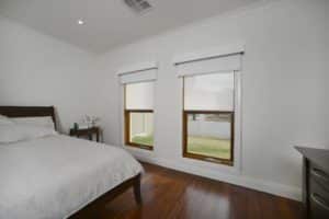 white roller blinds installed in bedroom