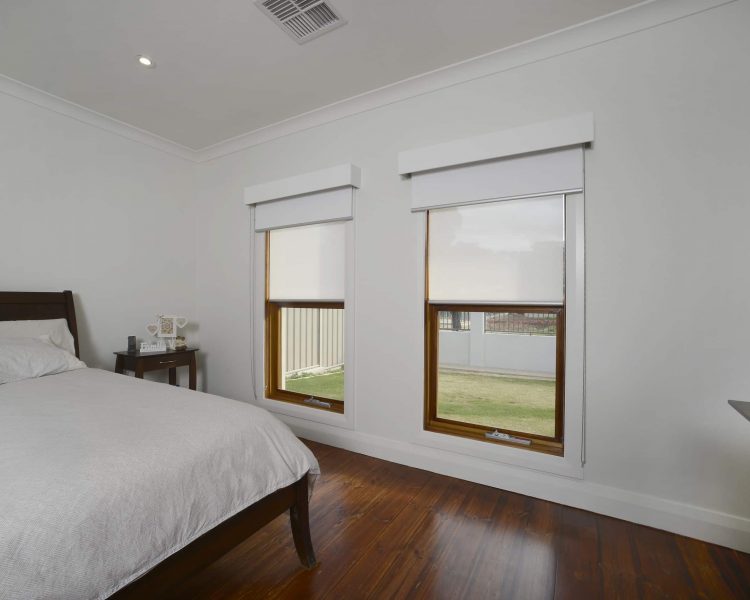 white roller blinds installed in bedroom